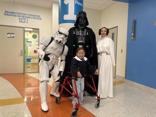 A galaxy far, far away came a little closer to Miller Children’s & Women’s Hospital as patients and families enjoyed a surprise visit from Star Wars favorites on “May the Fourth.” Among those visited was Bella Gamino, a smiling 7 year old patient in the Cherese Mari Laulhere Children’s Village, as she prepared for her first appointment of the day.