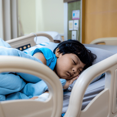 Child in hospital bed sleeping due to sickness.