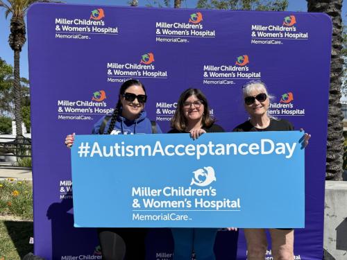 From right to left, LeAnn Beausoleil, mother of Emmalee Belteran; Emmalee Belteran; and her grandmother, Marie Beausoleil, hold an Autism Acceptance Day sign during the celebration at Miller Children’s & Women’s Hospital. Emmalee, a patient at the Stramski Children’s Developmental Center, recently turned 18 and is heading off to college after graduating high school this May.