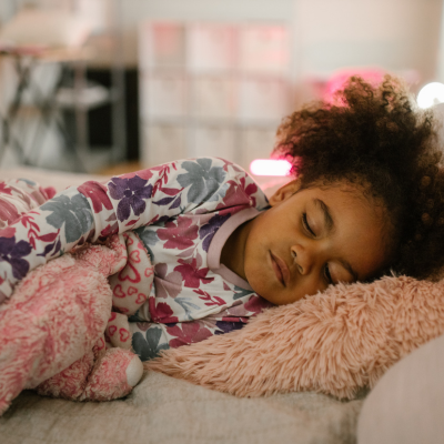 Little girl sleeping in pink room.