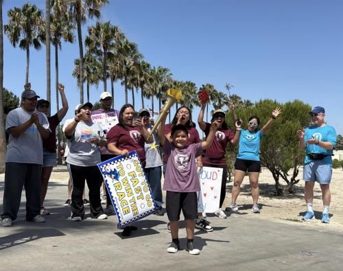 Jerry, a patient at the Jonathan Jaques Children’s Cancer Institute, lifts a torch as supporters cheer him on during the 39th annual Champions Run for Life “Torch Run.”