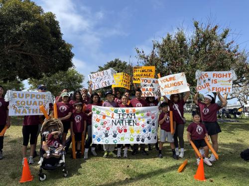 Surrounded by colorful banners, signs and orange clappers, Nathen’s family runs in support of the 13-year-old, who is undergoing cancer treatment at the Jonathan Jaques Children’s Cancer Institute, during the 39th annual Champions Run for Life “Torch Run.”