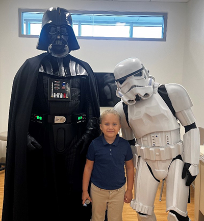 Jenessis, five-year-old Jonathan Jaques Children’s Cancer Institute patient, with Darth Vader and a Stormtrooper.