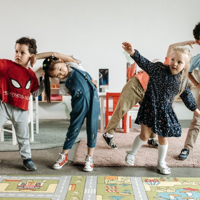 Children dancing in classroom setting.